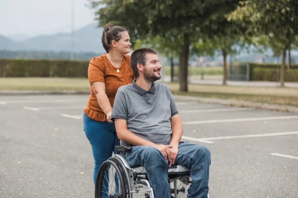 A disabled man in his wheelchair and his support worker in the garden
